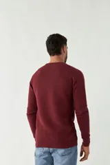 Sweater negro de punto con textura acanalada horizontal, cuello redondo y logo bordado en el pecho.