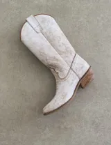 Botas de cuero color marrón y blanco con bordados negros, de estilo cowboy con taco bajo.
