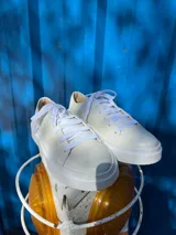 Championes blancos de cuero liso, con cordones y suela plana.