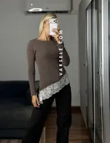 Blusa de manga larga color marrón, con corte asimétrico y detalle de puntilla blanca en el ruedo. Confeccionada en tejido de algodón y viscosa.
