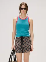 Musculosa de algodón color turquesa, con puños y ribetes en color fucsia contrastante, de diseño básico y logo bordado en el centro del pecho.
