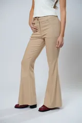 Pantalón de tiro alto color beige, con cierre frontal con cremallera y botón, bolsillos delanteros y traseros, y corte evasé en el bajo.