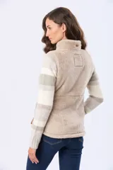 Chaleco de sherpa con cierre frontal, cuello alto y bolsillos laterales. Presenta detalles en cuero sintético en los tiradores de los cierres.