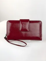 Billetera grande de cuero vacuno con textura granulada y detalles en charol. Cuenta con múltiples ranuras para tarjetas y cierre de solapa con broche a presión grabado con el logo de la marca.