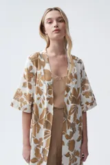 Kimono largo color crudo con estampado de hojas color camel, mangas tres cuartos y cinto para atar en la cintura.