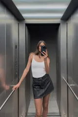 Camiseta ajustada negra con escote redondo y tirantes finos.