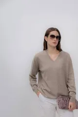 Sweater color beige de cashmere con escote en V y mangas largas.