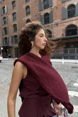 Chal tejido bordó con sutil brillo de lurex y delicadas terminaciones artesanales en los bordes.