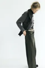 Jeans de tiro medio con corte barrel leg y diseño de cinco bolsillos. Presenta un acabado con efecto lavado y tintado único, con cierre frontal de cremallera y botón.