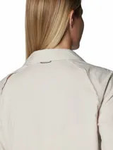Camisa de senderismo de manga larga en color beige, con cuello clásico, cierre frontal con botones y bolsillos funcionales en el pecho. Cuenta con tecnología de protección solar y ventilación trasera para mayor transpirabilidad.