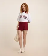 Short pollera color bordó de punto roma con frente cruzado.