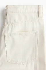 Pantalón jean de tiro alto en color crudo, con diseño de cinco bolsillos, corte recto y holgado de cadera a bajo.