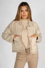 Sobrecamisa negra de paño con bordados geométricos en color crudo en el cuello, solapas, puños, bolsillos y bajo. Tiene cierre frontal con botones y bolsillos laterales.