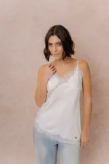 Musculosa de satén color crema con breteles finos regulables, escote en V y detalles de encaje en el escote, en diagonal sobre el delantero y en el ruedo.
