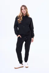 Pantalón de jogging de felpa, color beige, con cintura elástica ajustable mediante cordón y puños acanalados en los tobillos.