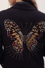 Saco sastrero negro de corte clásico con solapas, manga larga y gran diseño bordado de mariposa en la espalda con detalles metalizados.
