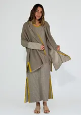 Saco azul de tejido de punto con rayas horizontales en tonos grises y detalles en rojo. Tiene corte holgado, mangas 3/4 y bolsillos laterales.