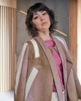 Tapado beige de lana merino afieltrada con teñido artesanal tie dye. Tiene cuello que se prolonga a modo de cinto, aberturas y bolsillos laterales.