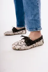 Mocasín de estilo náutico confeccionado en cuero gamuzado color tostado, con cordones decorativos laterales y en el empeine.