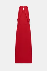 Vestido largo de corte fluido con cuello halter y espalda descubierta. Presenta un detalle de drapeado lateral y bajo recto.