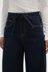 Pantalon tipo jean de corte barrel, con cintura media, bolsillos laterales y cierre con cordón ajustable en la cintura.