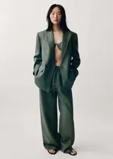 Pantalón de lino color verde militar, de corte recto y tiro medio. Presenta cintura elástica con cordón ajustable, bolsillos laterales y forro interior de algodón.