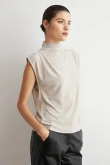 Blusa de lurex negra sin mangas, con cuello alto drapeado y detalle de pliegues frontales.