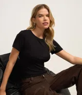 Blusa básica de manga corta, confeccionada en viscosa y elastano, con textura acanalada y terminación ondulada en el bajo.