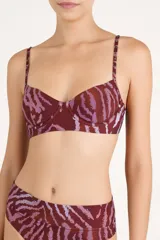 Top de bikini estructurado tipo corsetero, con aro, tirantes finos con tachas metálicas y diseño con estampado animal print en tonos bordó y rosado.