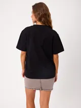 Remera lisa de manga corta, color blanco, con cuello redondo y calce holgado.