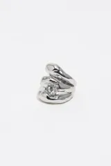 Anillo triple de diseño orgánico con acabado metálico plateado y un cristal central engastado.