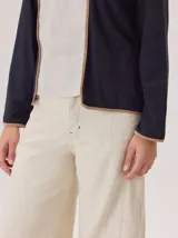 Remera de manga larga en color negro, con diseño de cuello redondo y terminaciones con vivos en contraste color beige. Presenta un corte recto y minimalista.