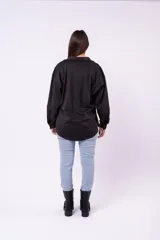 Camisa de estilo sobrecamisa en color beige, confeccionada en tela tipo gamuza o cuero sintético. Presenta cuello clásico, cierre frontal con botones, bolsillos delanteros con solapa y mangas largas con puños abotonados.