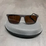 Lentes de sol con filtro UV 400 y armazón color naranja con detalle en la patilla.