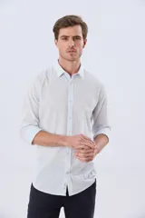 Camisa de lino de corte slim fit, con diseño de rayas sutiles, cuello camisero, mangas largas y cierre frontal con botones.