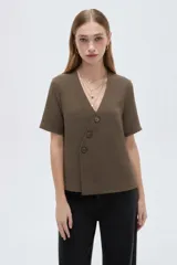 Blusa marrón de manga corta con cuello en V y cierre frontal cruzado con tres botones.