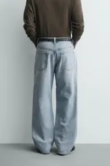 Pantalón jeans de corte recto y ajuste holgado, confeccionado en denim de algodón rígido. Presenta diseño clásico de cinco bolsillos, cierre frontal con cremallera y botón, con un acabado de lavado claro.
