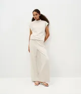 Pantalón de corte recto y tiro alto en tejido rib color beige, con cintura elástica.