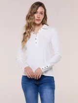 Remera de silueta al cuerpo de tejido de punto acanalado blanco, con cuello polo, abertura frontal con botones dorados y mangas largas con puños abotonados.