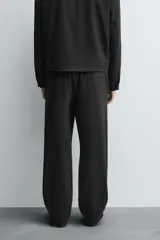 Pantalón regular fit color marrón oscuro, confeccionado en tejido con viscosa. Cuenta con cintura elástica, bolsillos delanteros y detalle de bolsillos traseros de vivo. El cierre frontal es con cremallera y botón.