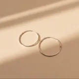 Aros tipo argolla de diseño minimalista, combinando plata y detalles en oro.