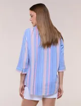 Blusa de silueta relajada con textura tramada, color azul con rayas verticales en tonos rosados, celestes y amarillos. Cuenta con cuello mao abierto en V y mangas tres cuartos amplias con pequeña abertura lateral en el puño.