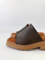 Sandalias de cuero color chocolate, con tira ancha sobre los dedos y suela de goma con plataforma.