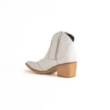 Bota tipo texana de caña baja en color blanco, con taco cuadrado de madera y punta fina. Presenta costuras decorativas en el lateral y un diseño clásico de estilo western.