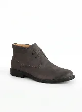 Bota corta tipo botineta de cuero negro con textura granulada, cierre mediante cordones y suela plana de goma.