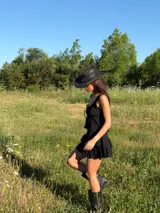 Top de tirantes finos con escote cuadrado, confeccionado en tela ligera con detalle de encaje en el borde y lazos frontales ajustables.