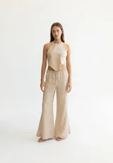 Pantalón color beige de lino, con elástico y tira ajustable en la cintura, bolsillos a ambos lados y pata de elefante estilo Oxford.