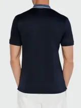 Remera polo blanca de corte slim fit, confeccionada en algodón. Presenta cuello clásico con rayas color crema y naranja, y cierre de dos botones. Marca BOSS, modelo PHILLIPSON.