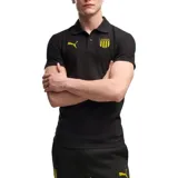 Remera polo Puma del Club Peñarol, modelo Evostrip, color negro con detalles en amarillo. Cuenta con cuello camisero, botonera frontal y el escudo del club junto al logo de la marca bordados en el pecho.