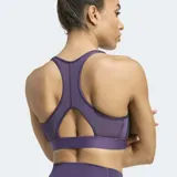 Top deportivo Adidas modelo Powerreact en color violeta, diseñado para entrenamientos de impacto medio. Confeccionado con tecnología CLIMACOOL para mayor transpirabilidad, presenta un cuello cuadrado, espalda deportiva y paneles de malla. Incluye almohadillas removibles y las clásicas tres tiras laterales en contraste.